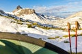 Tent and hiking sticks in snowy mountain landscape. Trekking in Swiss Alps. Hoch Turm, Charetalp, Switzerland.