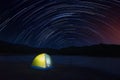 Tent at night on star trail background