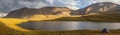 Tent on the shore of a mountain lake. Panoramic view, evening light Royalty Free Stock Photo