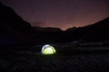 Tent standing on a mountain pasture under starry sky