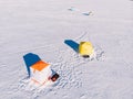 Tent for winter ice fishing, top aerial view, fisherman holding rod in hole lake