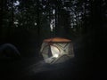 Tent in the woods, lantern light from within Royalty Free Stock Photo