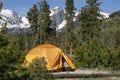 Tenting in Orange tent camping with Hallet Peak and snow covered Rocky Mountains of Colorado Royalty Free Stock Photo