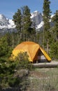 Tenting in orange tent camping with Hallet Peak and snow covered Rocky Mountains of Colorado Royalty Free Stock Photo