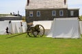 Tents and artillery set up in front of stone buildings during reenactments, Fort Ontario, New York, 2016