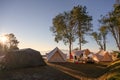 Tents camping in campsite on hill with sunrise over mountain at national park Royalty Free Stock Photo