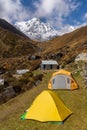 Tents on grass in Machapuchare Base Camp with background of Annapurna South Mountain Royalty Free Stock Photo