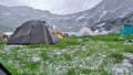 Tents during hail and cold rain in Summer, midday at Lake Bucura, Retezat mountains. View from inside a tent. Royalty Free Stock Photo