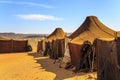 Tents in the middle of desert with mountains in the background, on a sunny day Royalty Free Stock Photo