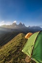 Tents on a mountain edge in front of the Aiguille d'Arves at sun