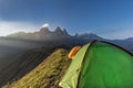 Tents on a mountain edge in front of the Aiguille d'Arves at sun