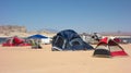 Tents pitched in the desert beside a reservoir in the summertime
