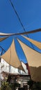 Tents tied to a rope in a grassy outdoor space, providing a shaded area from the sun