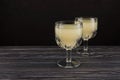 Tepache - traditional Mexican fermented drink from pineapple. Homemade kvass in drinking glasses on wooden table. Dark background