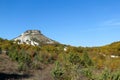 Tepe Kermen Cave City near Bakhchysarai in Crimea surrounded by colorful autumn forest under bright blue sky Royalty Free Stock Photo