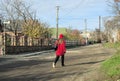 Teplyk, Ukraine - November, 17 2023: girl in red coat and hat walking