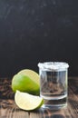 Tequila shot and lime slice on wooden table/Tequila shot and lime slice on wooden table with copy copyspace dark background Royalty Free Stock Photo