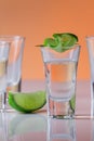 Tequila shot with a slice of lime on the glass orange background Royalty Free Stock Photo