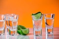 Tequila shot with a slice of lime on the glass orange background Royalty Free Stock Photo