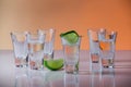 Tequila shot with a slice of lime on the glass orange background Royalty Free Stock Photo