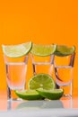 Tequila shot with a slice of lime on the glass orange background Royalty Free Stock Photo