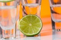 Tequila shot with a slice of lime on the glass orange background Royalty Free Stock Photo