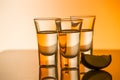 Tequila shot with a slice of lime on the glass orange background Royalty Free Stock Photo
