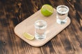 Tequila shots with lime slices and salt on wooden support /Tequila shots and lime slice on wooden table. Top view Royalty Free Stock Photo