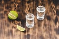 Tequila shots with lime slices and salt on wooden table/Tequila shots and lime slice on wooden table Royalty Free Stock Photo