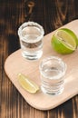 Tequila shots with lime slices and salt on wooden table/Tequila shots and lime slice on wooden table. Top view Royalty Free Stock Photo