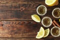 Tequila shots with salt, lime slices and cinnamon on wood table Royalty Free Stock Photo
