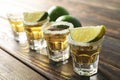 Tequila shots with salt and lime slices on wood table Royalty Free Stock Photo