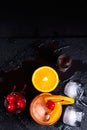 Tequila Sunrise cocktail, orange, ice cubes, maraschino cherries and jigger on a wet black slate tray. Cocktail Set. Top view with Royalty Free Stock Photo