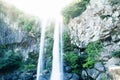 Water falling out of sunshine at Joengbang waterfall in Seogwipo, Jeju Island, South Korea