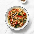 Teriyaki chicken, bell peppers, onions, spinach and rice noodles stir fry on white background, top view. Asian style Royalty Free Stock Photo