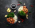 Teriyaki chicken, steamed broccoli and basmati rice served in two Asian clay bowls