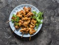 Teriyaki marinated duck skewers on a dark background, top view. Delicious snack, tapas, appetizers