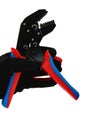 Terminal crimping press pliers with opened jaws, held in left hand in thin black nylon/polyester/spandex glove, white background.