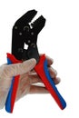 Terminal crimping press pliers with opened jaws, held in left hand in transparent glove used in electrotechnical installations