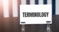 Terminology sign on paper on dark desk in sunlight. Blue and white background Royalty Free Stock Photo