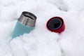 Thermos with a hot drink in snow