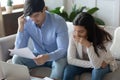 Thoughtful pensive young family studying financial documents of getting mortgage