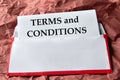TERMS and CONDITIONS - word on a white sheet with an envelope background and crumpled red paper Royalty Free Stock Photo