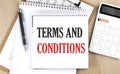 TERMS AND CONDITIONS is written in white notepad near a calculator, clipboard and pen. Business concept Royalty Free Stock Photo