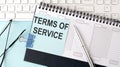 TERMS OF SERVICE text on blue sticker on the planning and keyboard,blue background Royalty Free Stock Photo