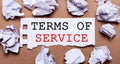 TERMS OF SERVICE written on white paper on a light brown background Royalty Free Stock Photo