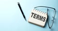 TERMS text written on a notepad on the blue background Royalty Free Stock Photo