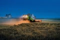 TERNOPIL REGION, UKRAINE - August 03, 2021: - CLAAS combine harvester works at night in a wheat field, evening lighting of reaping