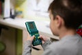 Ternopil, Ukraine - February, 2023: Boy is playing with an green electronic tetris