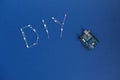 TERNOPIL, UKRAINE - May 5, 2019: DIY word from diode and arduino uno on a blue background. arduino board. DIY words for Do It